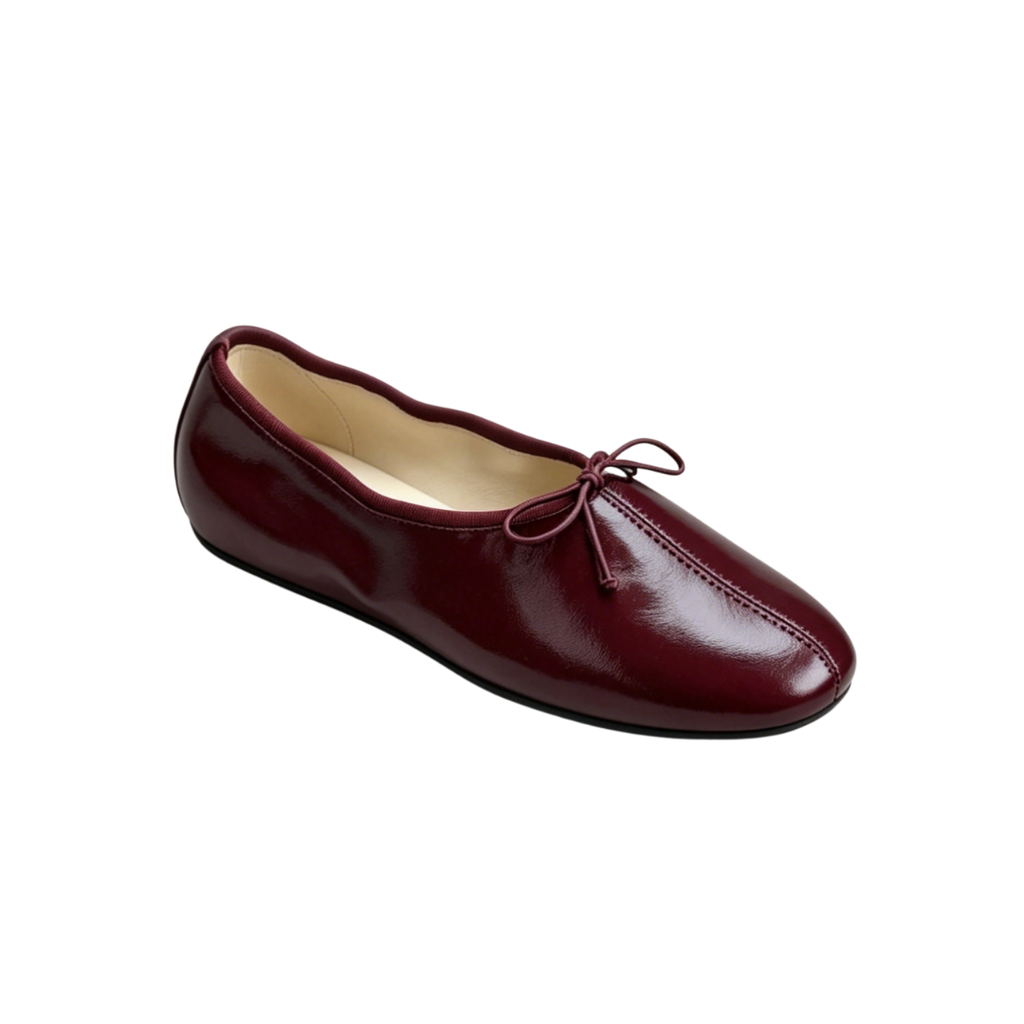 Maroon ballet flat shoe on a white background