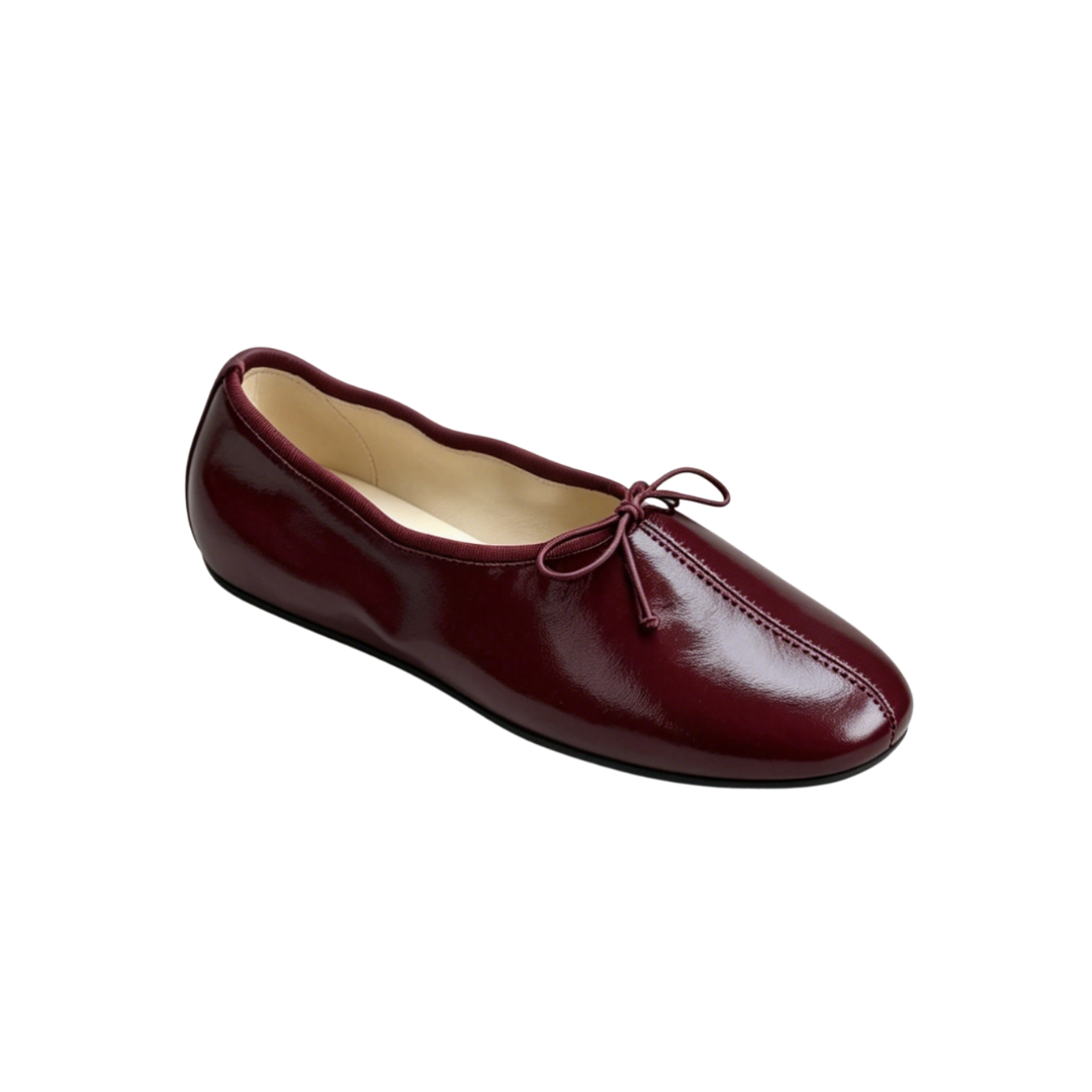 Maroon ballet flat shoe on a white background