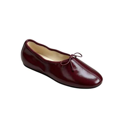 Maroon ballet flat shoe on a white background