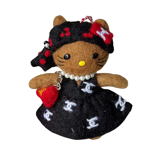 Felt doll with black dress and red accents on a white background