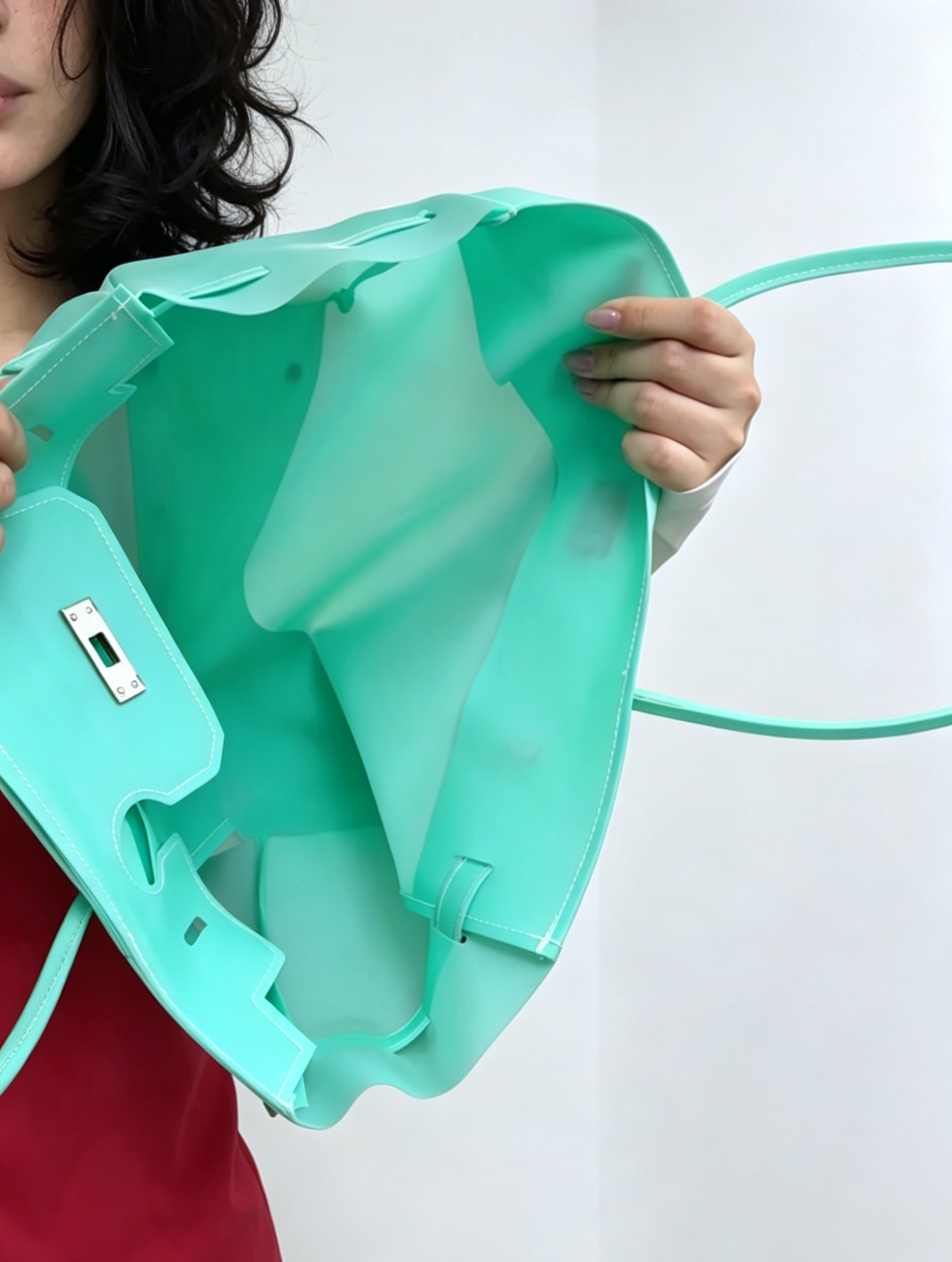 Turquoise plastic sheet held by a person on a white background
