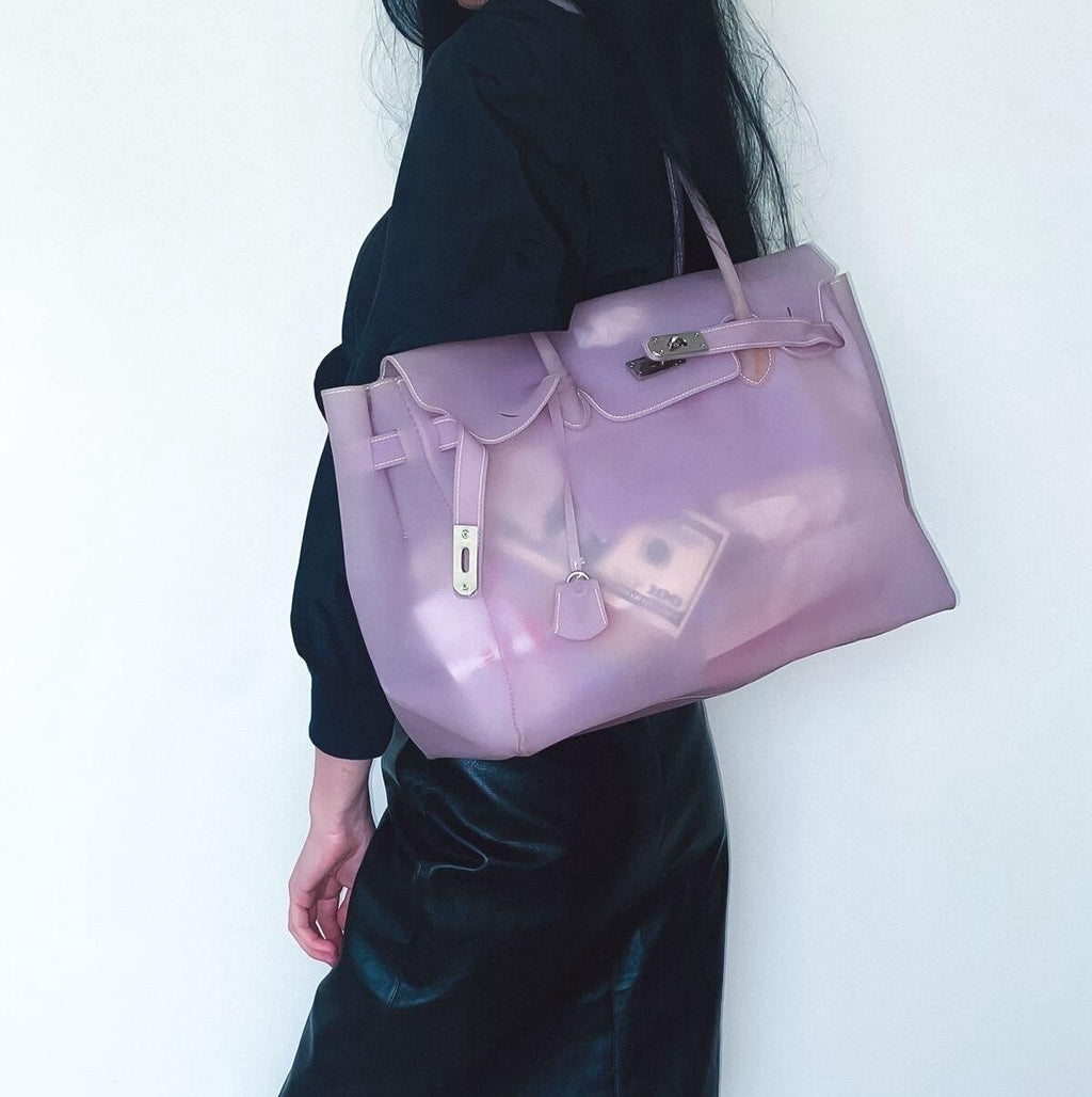 Person holding a lavender handbag against a white background