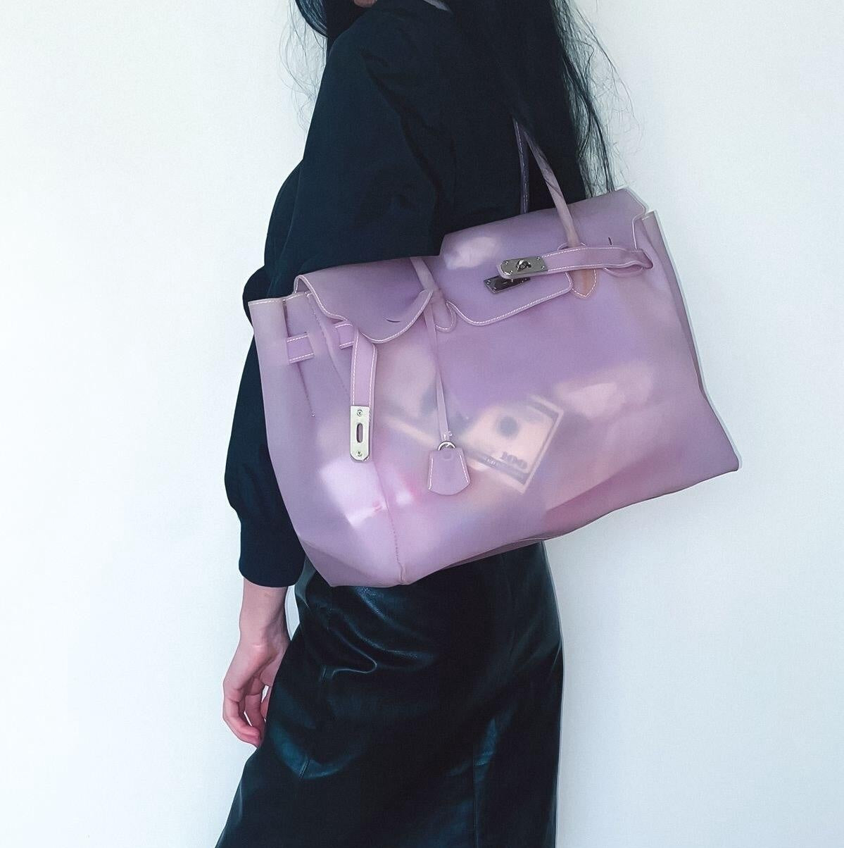 Person holding a lavender handbag against a white background