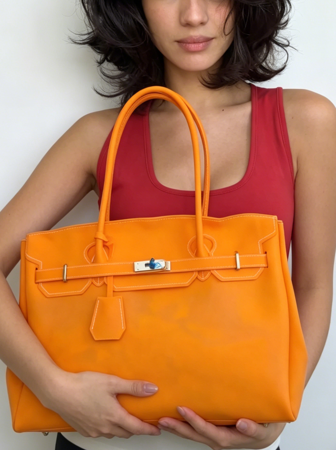 Jelly Firkin 40 Bag Classic Tangerine held by woman against white background